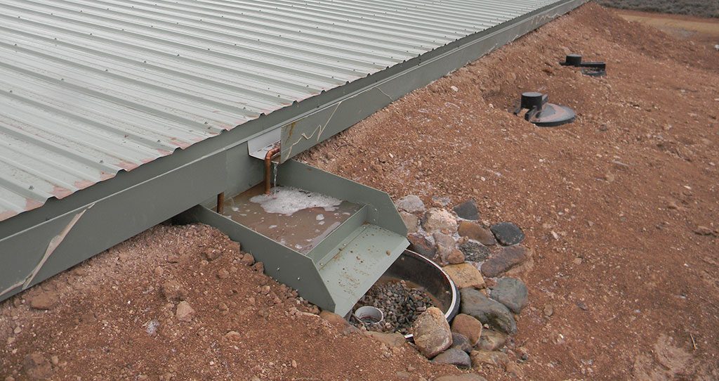 Rain and snowmelt running off a roof into a catchment system