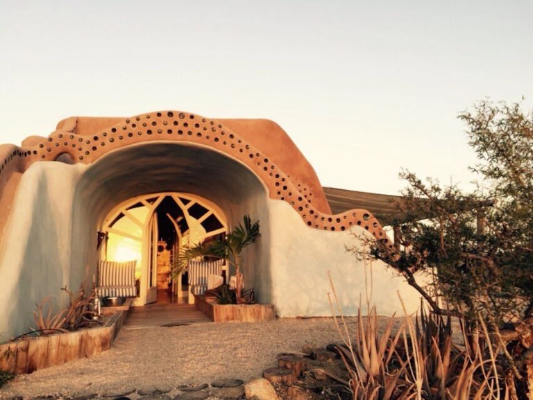 Arched bottle-wall entry of the Todos Santos Earthship at sunset
