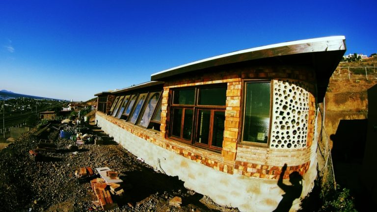 Wide-angle view of a Rosarito Beach Earthship with bottle-wall end and glazed front