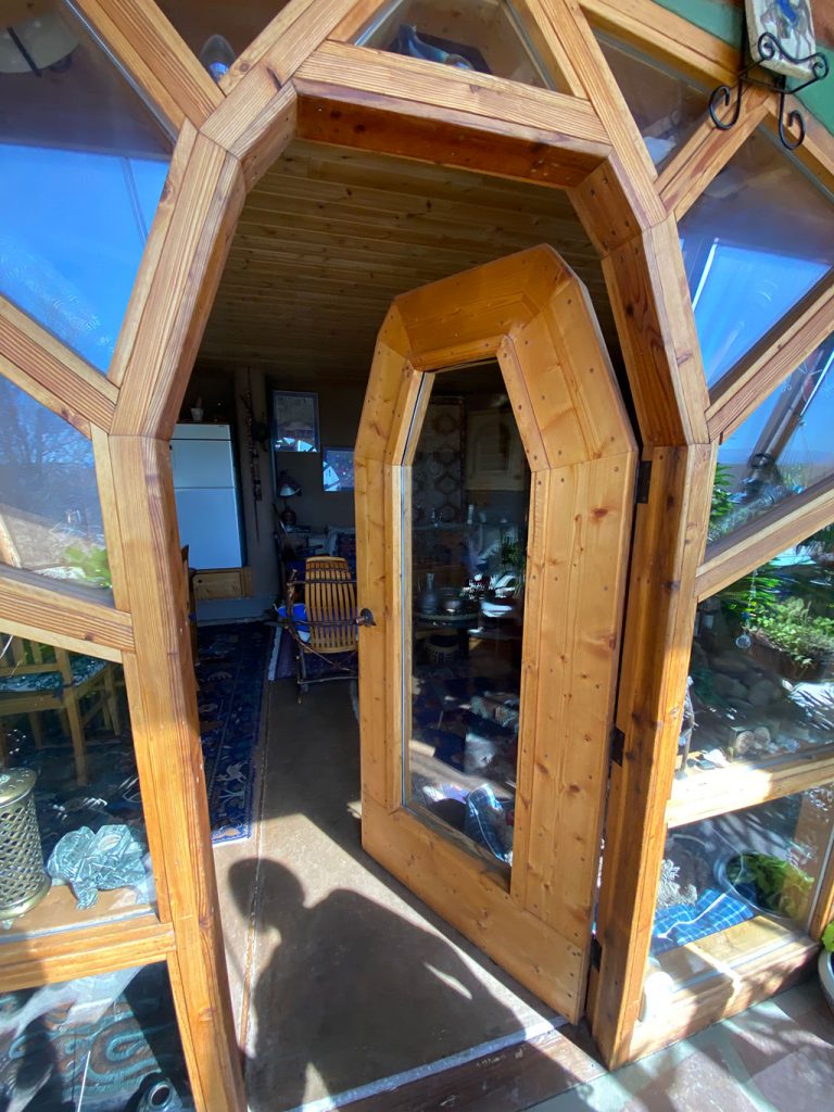 Faceted wood-framed glass entry door of a New Mexico Earthship