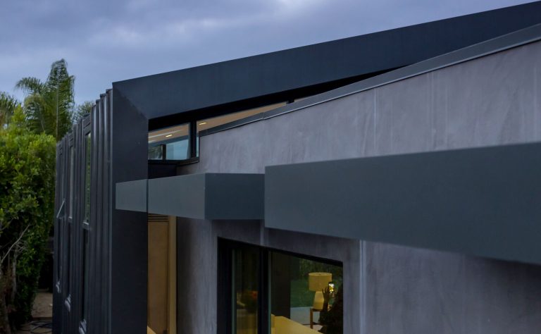 Close-up of the Morningside Remodel's wrapping metal gable and plaster wall