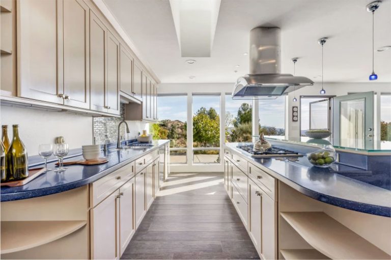 Galley kitchen with blue countertops and island in the West Hills concept house