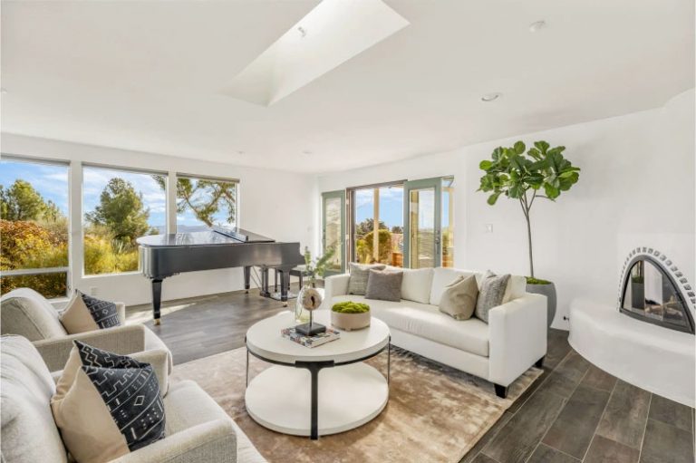 Living room with a grand piano and window walls in the West Hills concept house