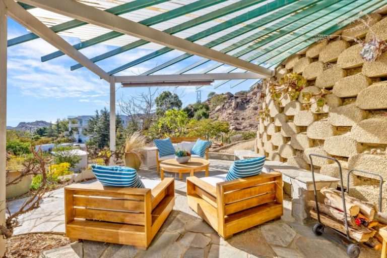 Covered patio beside a stacked-block retaining wall at the West Hills concept house