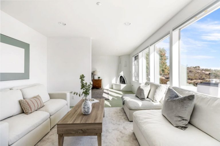 Sunroom lounge with white sofas and rock-outcrop views, West Hills, California
