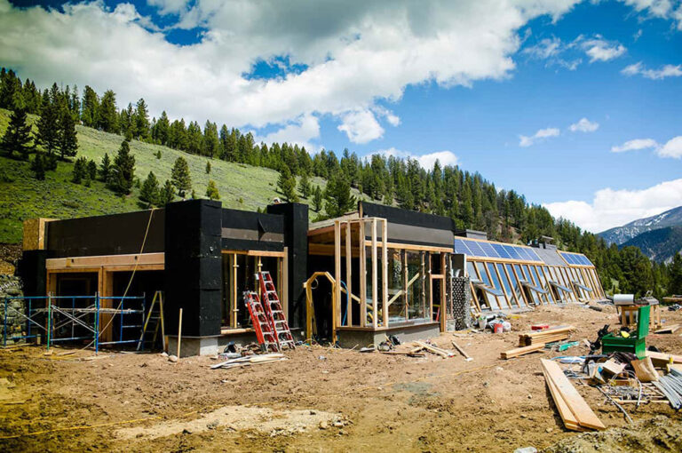 Montana Earthship under construction on a forested hillside