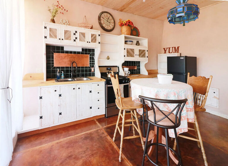 Bright kitchen with white cabinets and a small dining table