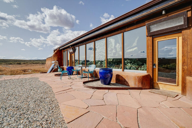 Flagstone patio along the glazed front of the Encounter Model Earthship