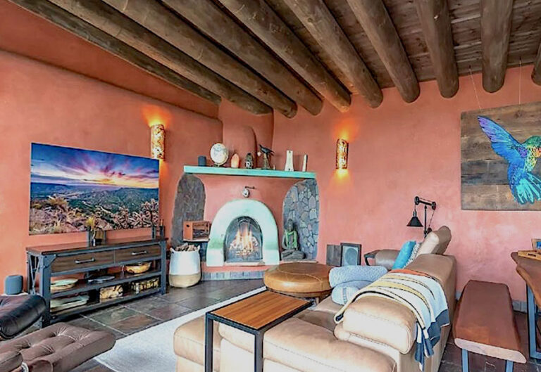 Living room with a plastered fireplace and wood viga ceiling