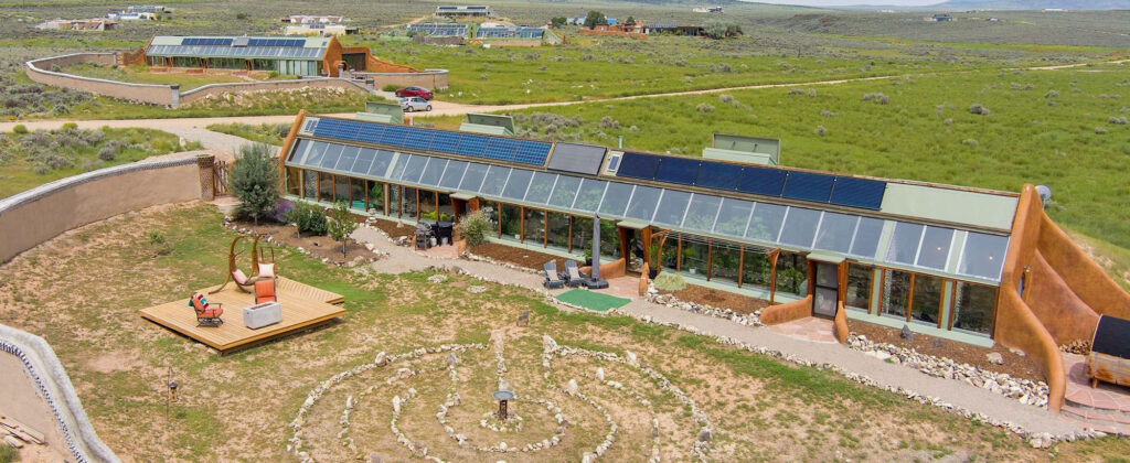 Aerial view of the Global Model Earthship: a long south-facing greenhouse front on open mesa