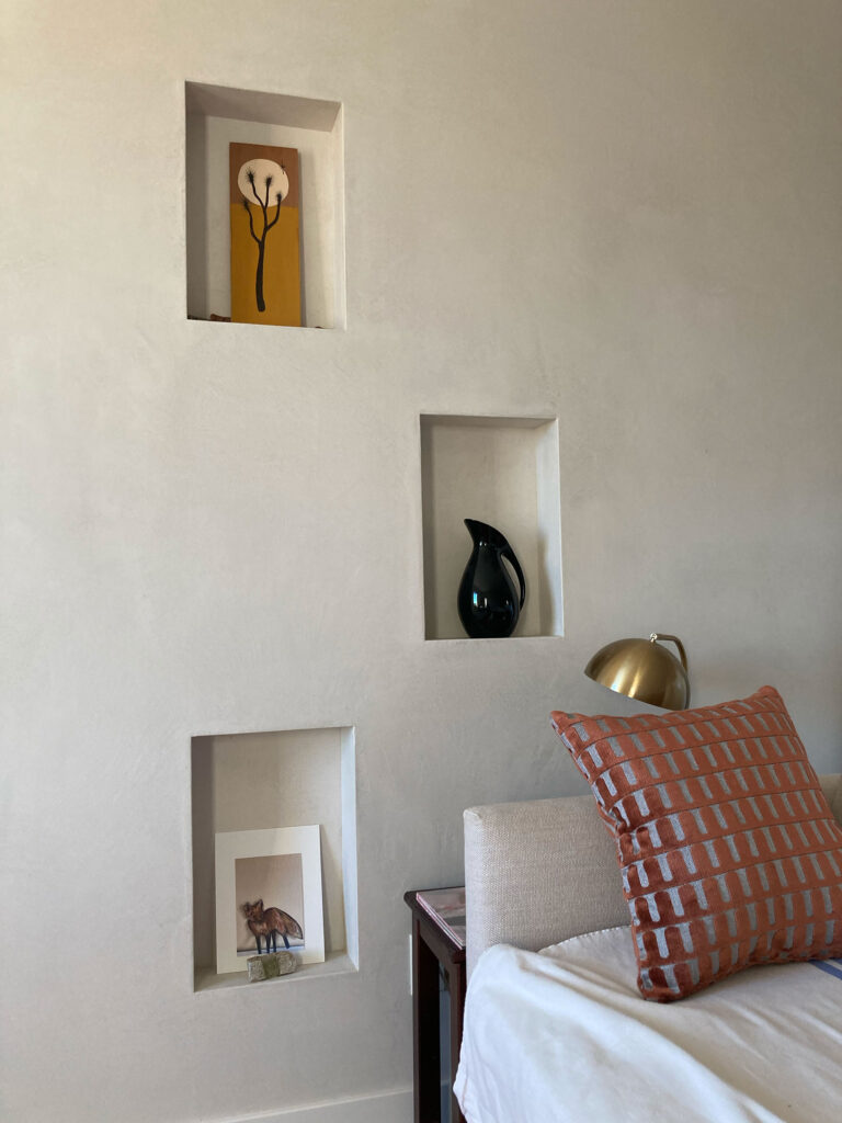 Plaster wall with built-in niches beside the living room