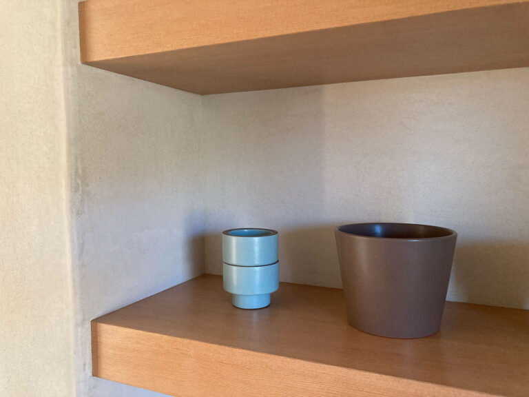 Floating wood shelf set into a plaster wall