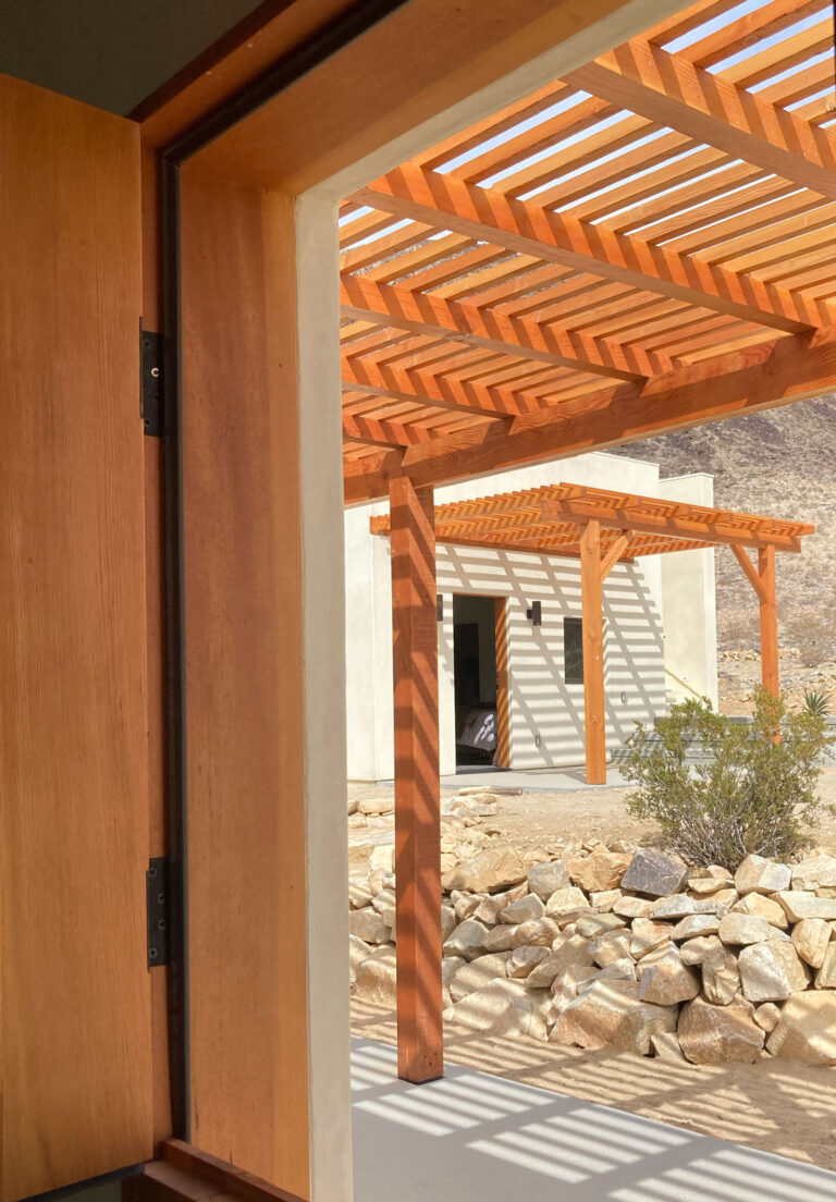 View out through the wood entry door to the pergola
